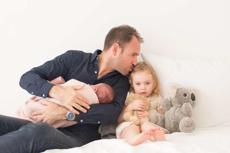 newborn Fotograaf Heerhugowaard, baby in papas armen op bed met zusje, fotografie, babyfotografie, pasgeboren